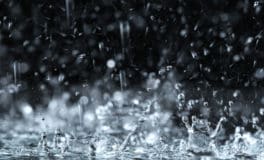 heavy rain with water splashing against a dark background